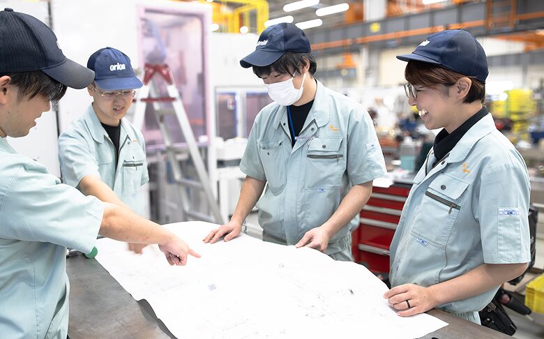 複数の社員で図面を確認しながら作業内容を相談する様子